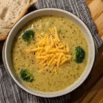 Broccoli Cheddar Soup Subway Recipe in a bowl with a spoon and a slice of bread.