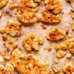 Cauliflower crisps on a plate with fresh vegetables.